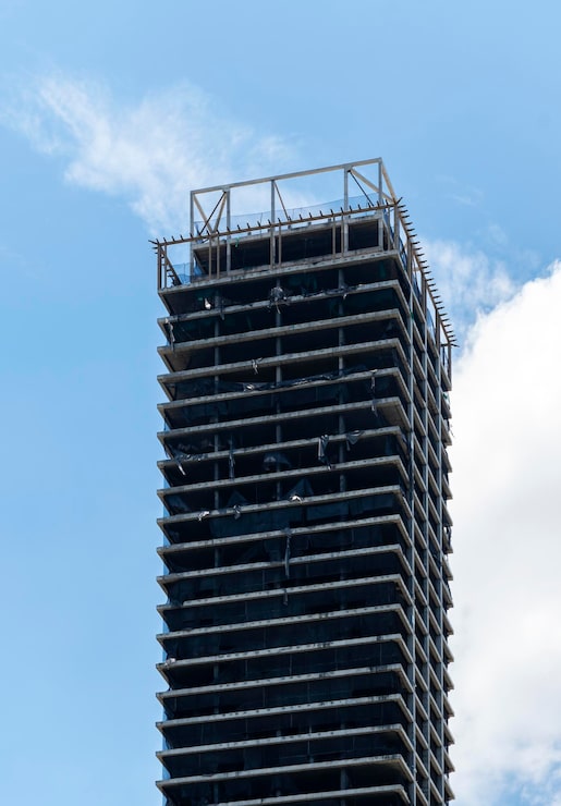 Foto edificio alto abandonado sobre fondo de cielo azul