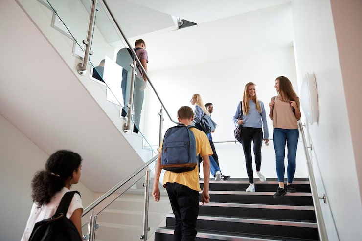 Foto estudiantes de secundaria caminando por las escaleras entre las lecciones en un ocupado edificio universitario