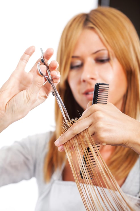 Foto friseur schneidet haare einer blonden frau