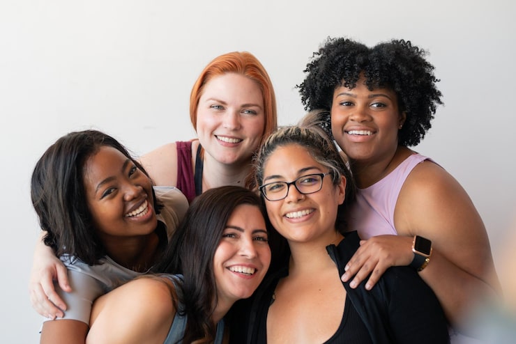Foto grupo feliz e diversificado de esportistas em roupas ativas, incluindo afro-americanas, caucasianas e hispânicas.