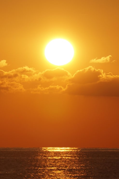 Foto hermosa puesta de sol detrás de las nubes sobre el mar