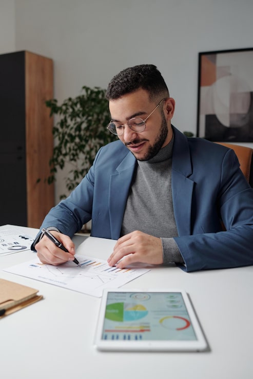 Foto hombre analizando el documento con gráficos estadísticos