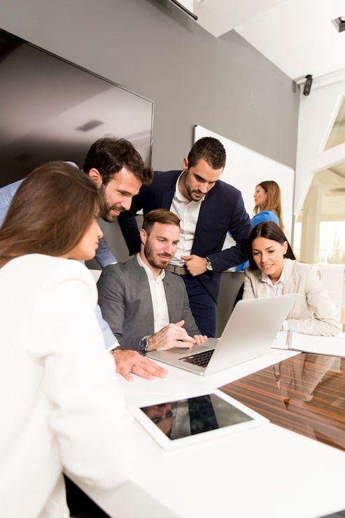 Foto jóvenes gerentes exitosos discutiendo nuevo proyecto empresarial en la oficina moderna