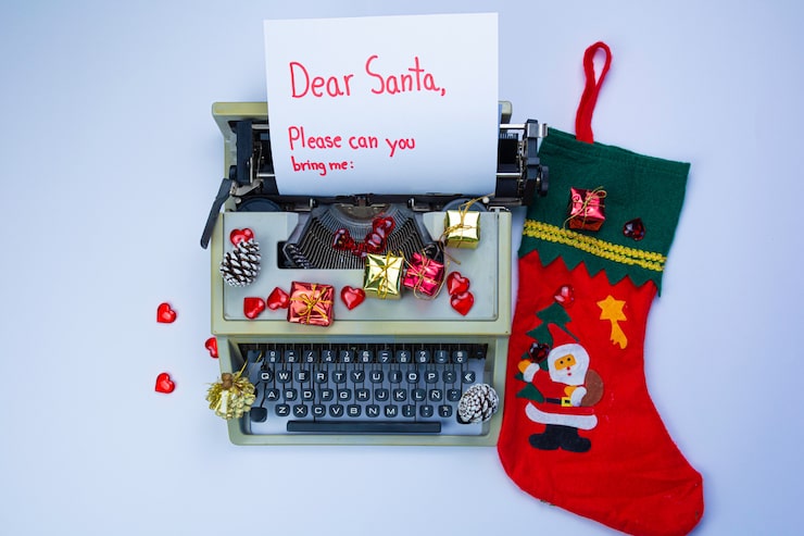 Foto máquina de escrever com a inscrição "querido papai noel", caixas de presente e ramos de abeto em branco