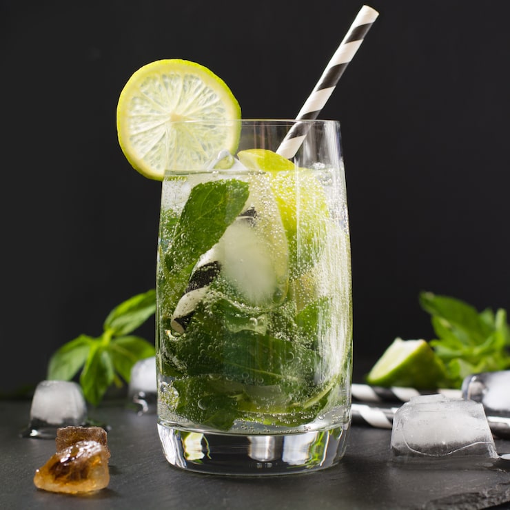 Foto mojito cocktail em vidro na mesa preta. foto chave baixa. fechar-se.