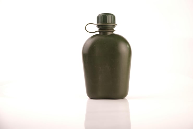 Foto no es un nuevo matraz de plástico verde militar sobre un fondo blanco con reflejo
