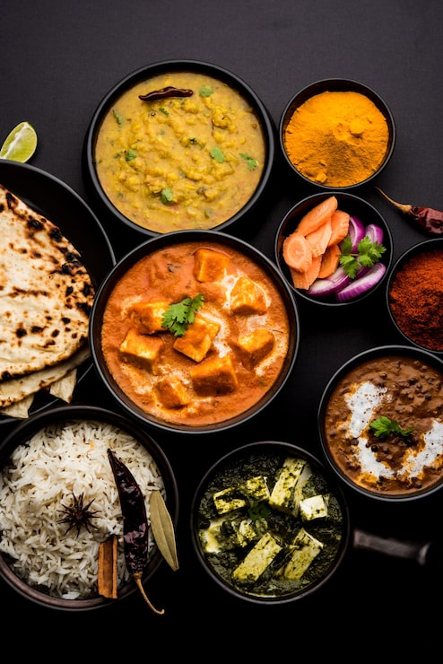Foto o prato principal do almoço ou jantar indiano em grupo inclui paneer butter masala, dal makhani, palak paneer, roti, arroz etc, foco seletivo