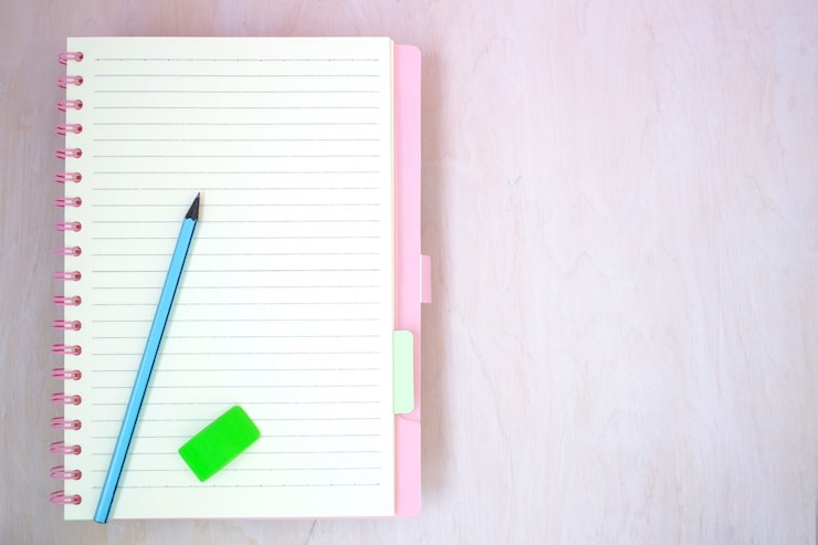 Foto papel de cuaderno vacío para texto con lápiz azul