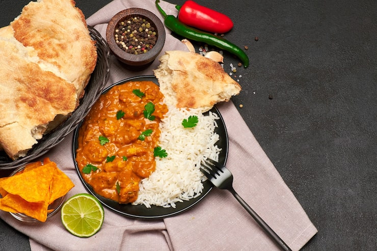 Foto prato de frango ao curry tradicional e arroz na mesa escura