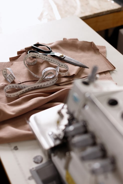 Foto suministros de costura y una máquina overlock en la fábrica.
