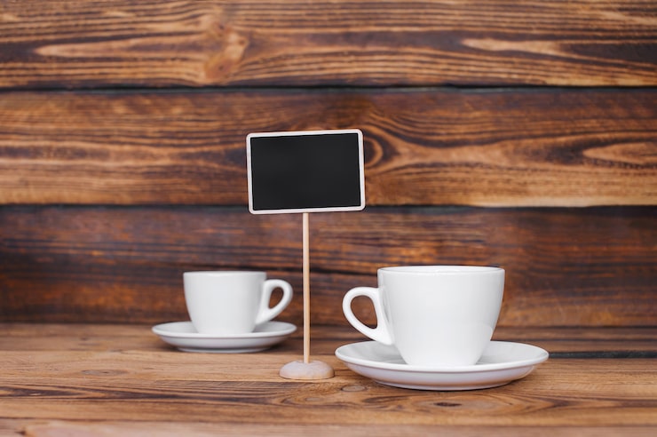 Foto tazas de café con leche con un cartel en una madera oscura.