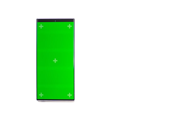 Foto telefone celular com uma tela verde vertical em telefone celular com tecnologia de smartphone com chave cromática de bonde em fundo branco isolado