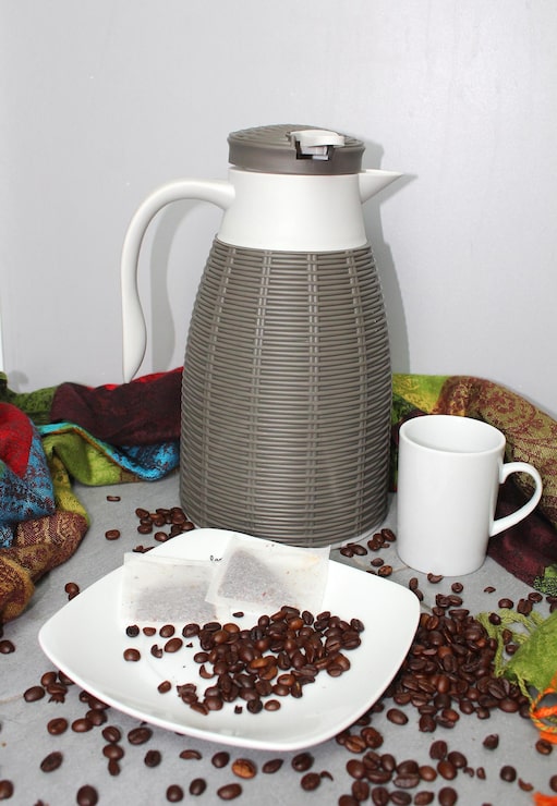 Foto vida muerta con una taza de termómetro y granos de café