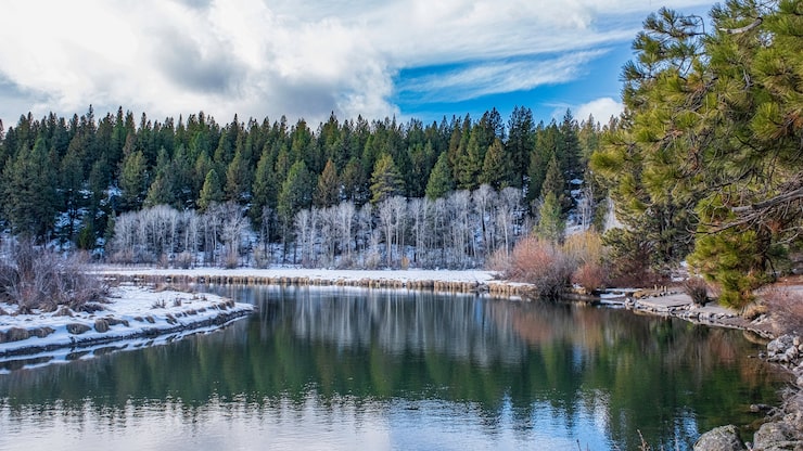 Gratis Foto fascinerende bilde av en vakker snødekt steinete park rundt innsjøen