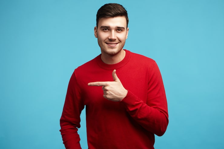 Gratis Foto isolert bilde av positiv, moderne ung mann med stilig frisyre og bust som smiler til kameraet