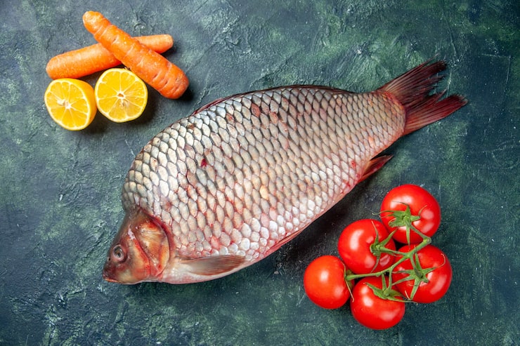Gratis Foto oversiktsbilde av fersk rå fisk med tomater på mørk blå bakgrunn