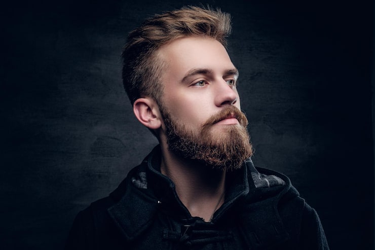 Gratis Foto portrett av en skjeggete urban mann isolert med kontrastbelysning på grå vignettbakgrunn.