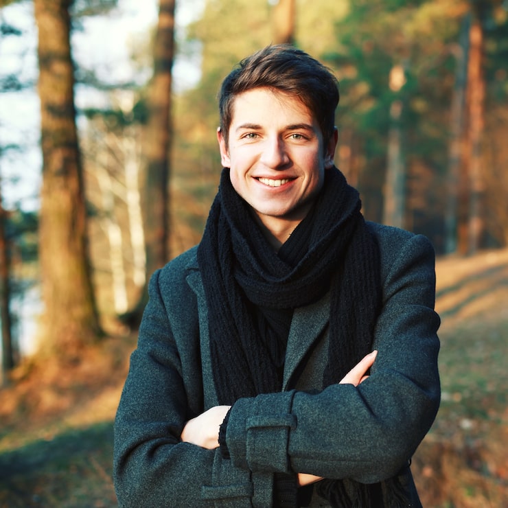 Gratis Foto smilende ung mann med kryssede armer utendørs