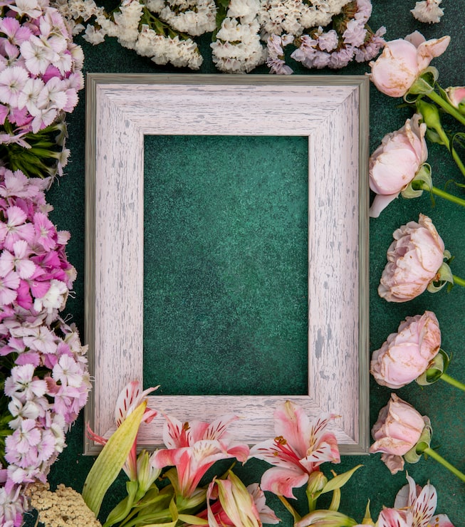 Gratis Foto topputsikt av grå ramme med lyse rosa blomster på en grønn overflate