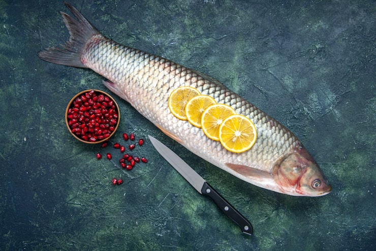 Gratis Foto topputsikt rå fisk granateplefrø i bolle kniv på bord