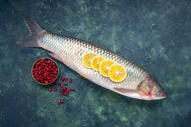 Gratis Foto topputsikt rå fisk granateplefrø i bolle på bord med ledig plass