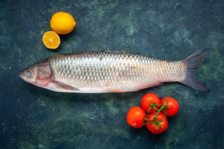 Gratis Foto topputsikt rå fisk tomater sitron på bord med kopiplass