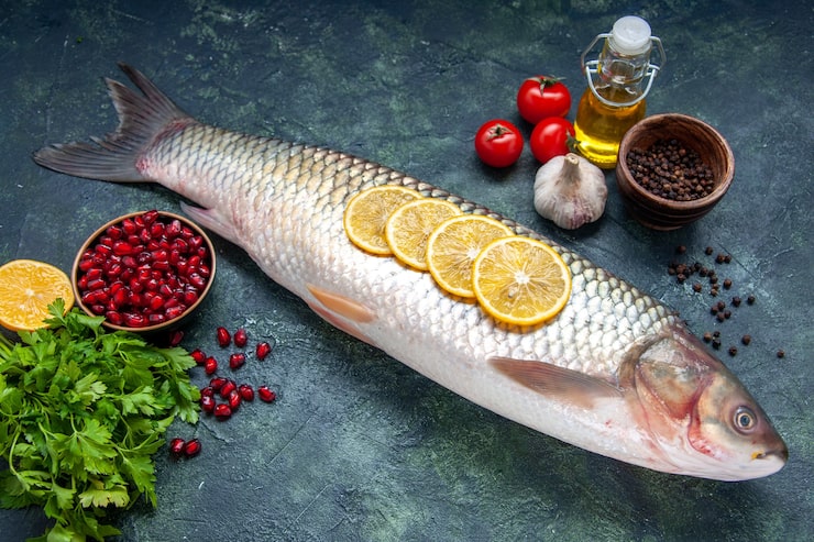 Gratis Foto undersidevisning av rå fisk, tomater, sitronskiver, oljeflaske, svart pepper på bordet