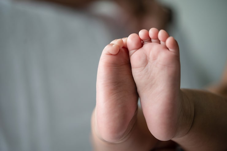 Gratis Foto babyfødder i hvid seng.