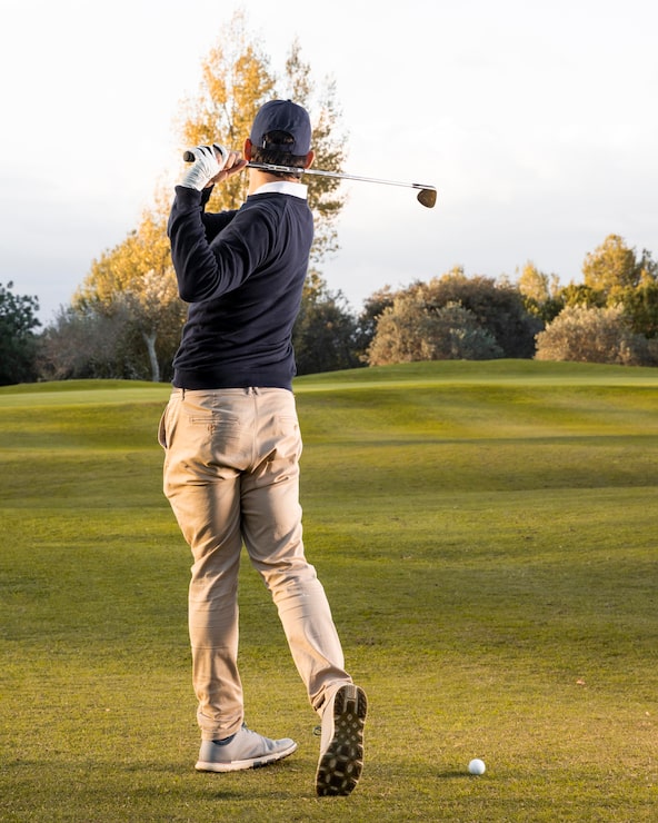 Gratis Bild baksida av man som spelar på den gräsbevuxna golfbanan