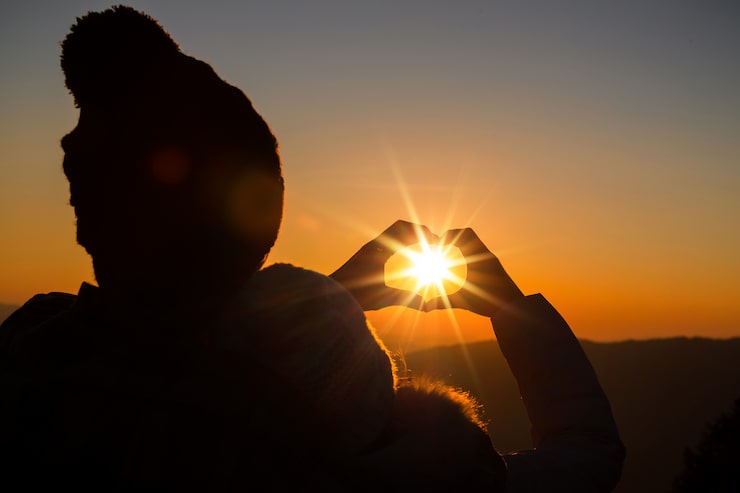 Gratis Foto forelsket par med baggrundsbelysning og silhuet på bakke ved solnedgang