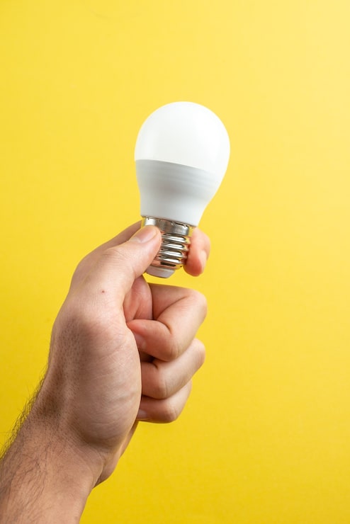 Gratis Bild framifrån: vit glödlampa i manliga händer på gul bakgrund, pappersfärgsfoto, ritblock, skola, college