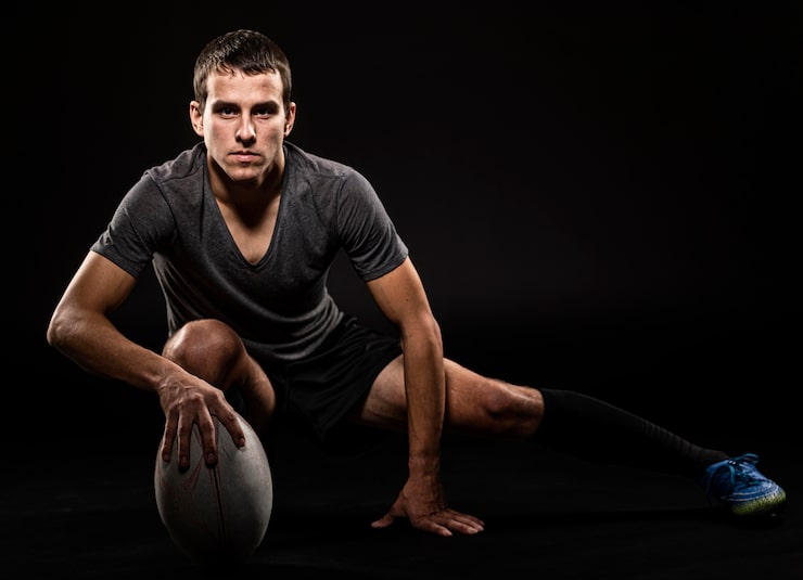 Gratis Bild frontvy av atletisk, stilig rugbyspelare som håller en boll med kopieringsutrymme