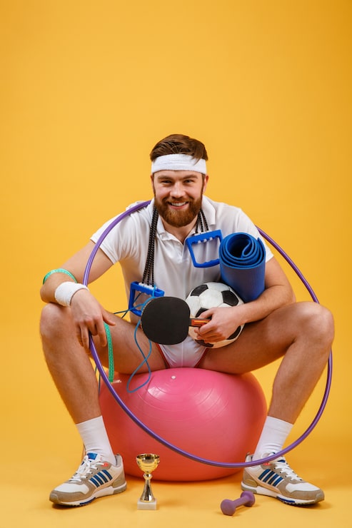 Gratis Bild glad och munter träningsman som sitter på en sportboll
