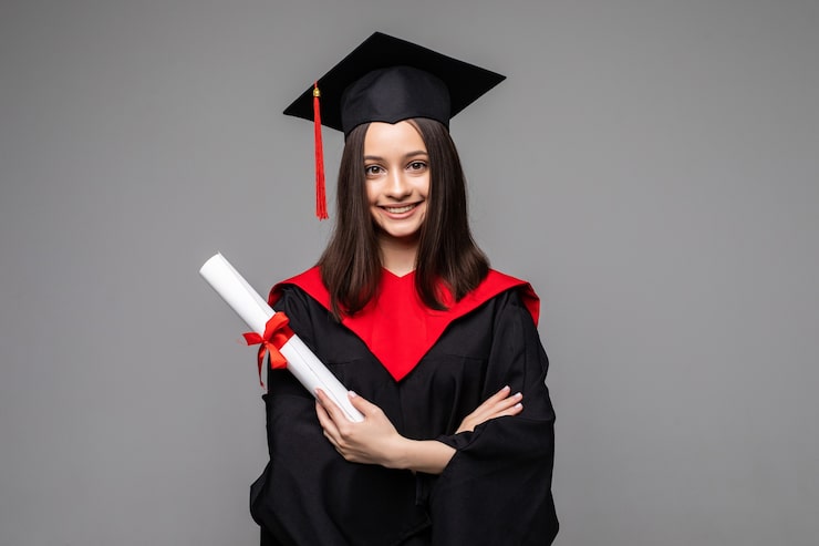 Gratis Bild glad student med studentmössa och examensbevis på grå bakgrund