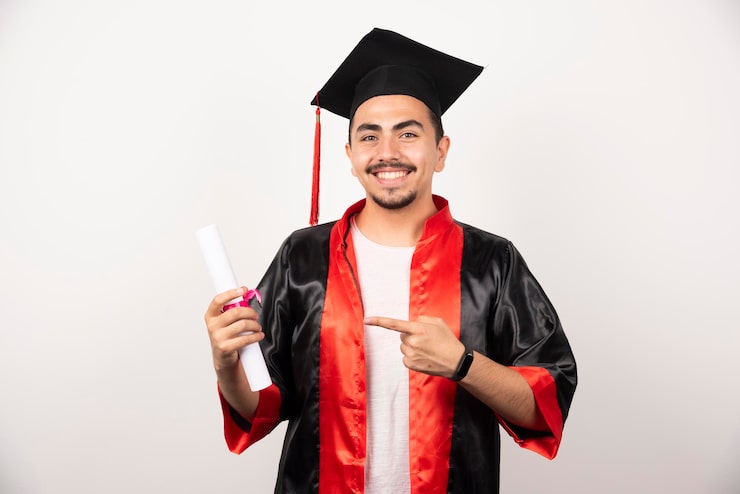 Gratis Bild glad student som pekar på diplom på vit bakgrund.