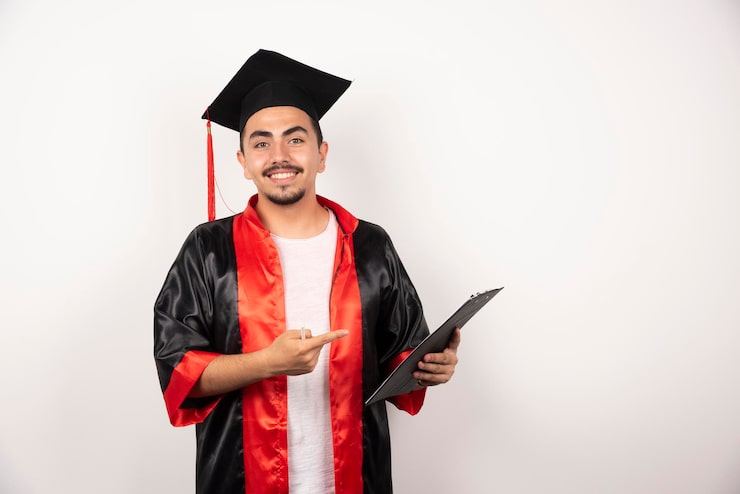 Gratis Bild glad utexaminerad student som pekar på sitt diplom på vitt.
