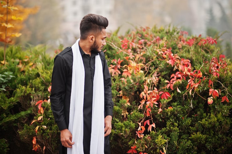 Gratis Bild indisk stilig man i svarta traditionella kläder med vit scarf poserade utomhus mot gult höstlövsträd