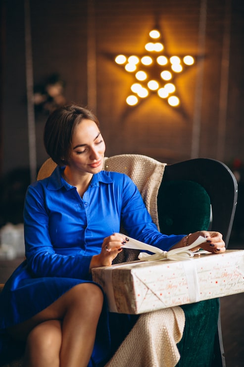 Gratis Bild kvinna packar upp presenter vid julgranen