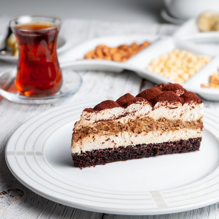 Gratis Bild läckra dessert på en tallrik med te, nötter hög vinkelvy på en vit träbakgrund