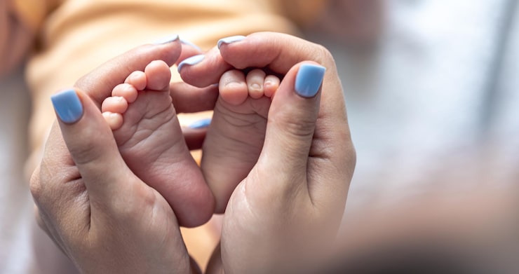 Gratis Foto mor holder benene på en nyfødt baby i sine hænder