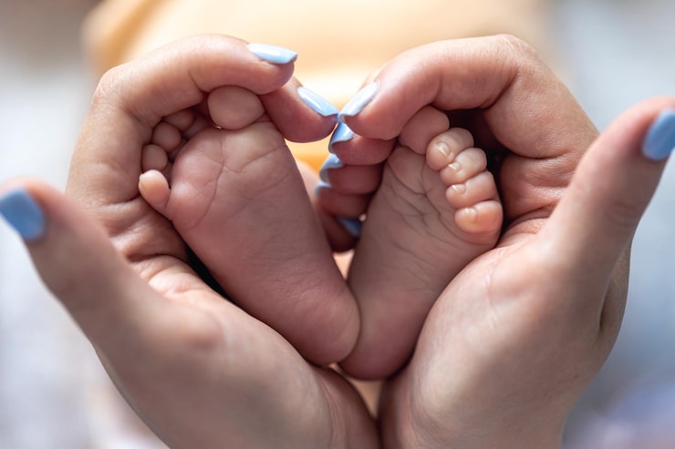 Gratis Foto mor holder benene på en nyfødt baby i sine hænder