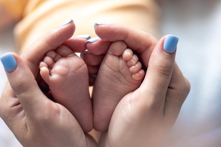 Gratis Foto mor holder benene på en nyfødt baby i sine hænder