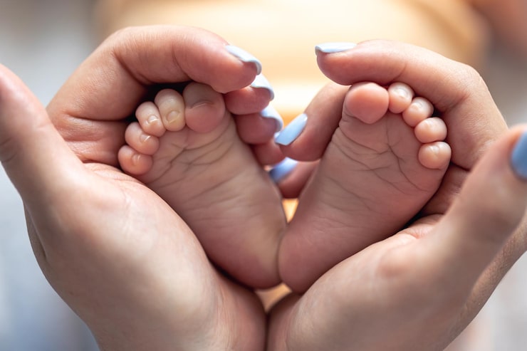 Gratis Foto mor holder benene på en nyfødt baby i sine hænder