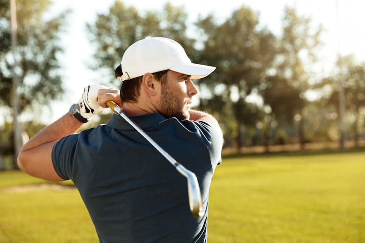 Gratis Bild närbild av en ung koncentrerad man som skjuter golfboll