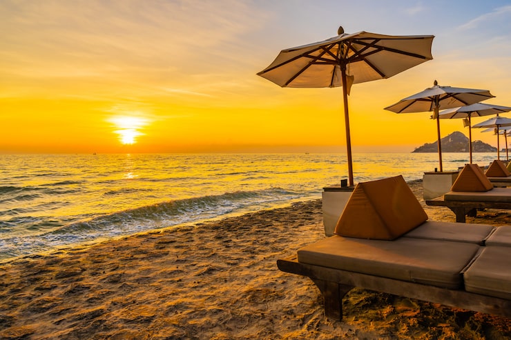 Gratis Bild parasoll och stol med kudde runt ett vackert landskap med strand och hav