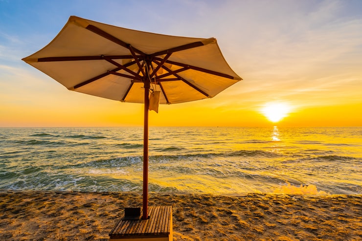 Gratis Bild parasoll och stol med kudde runt ett vackert landskap med strand och hav