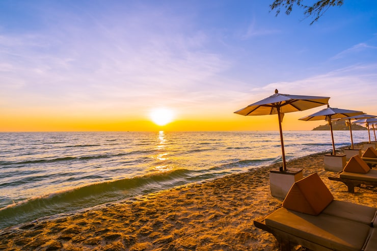 Gratis Bild parasoll och stol med kudde runt ett vackert landskap med strand och hav