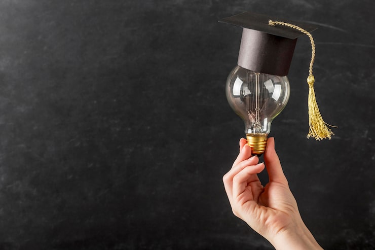 Gratis Bild person som håller en glödlampa med examenshatt