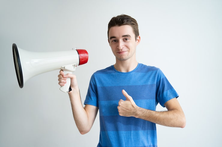 Gratis Foto positiv mand holder megafon og viser tommelfingeren op