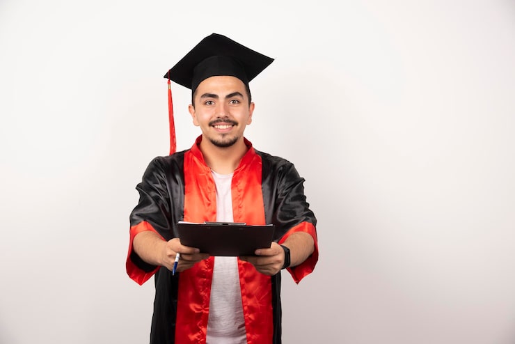 Gratis Bild positiv student som visar upp sitt examensbevis på vit bakgrund.